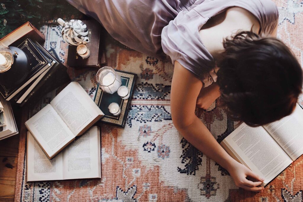 woman reading books on the floor